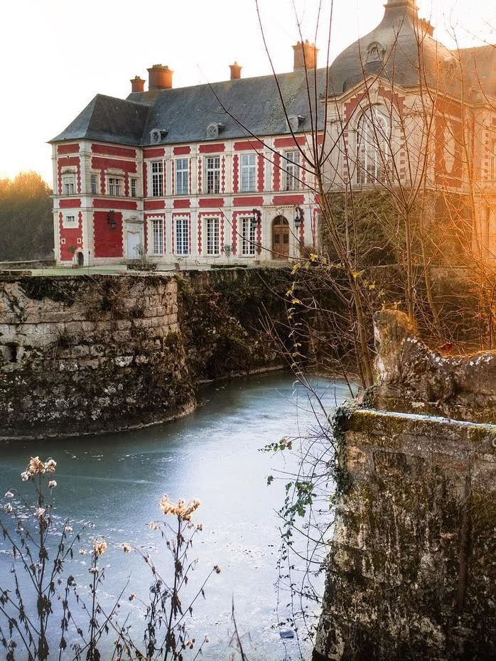 Le château et ses douves dans la lumière dorée de l'automne