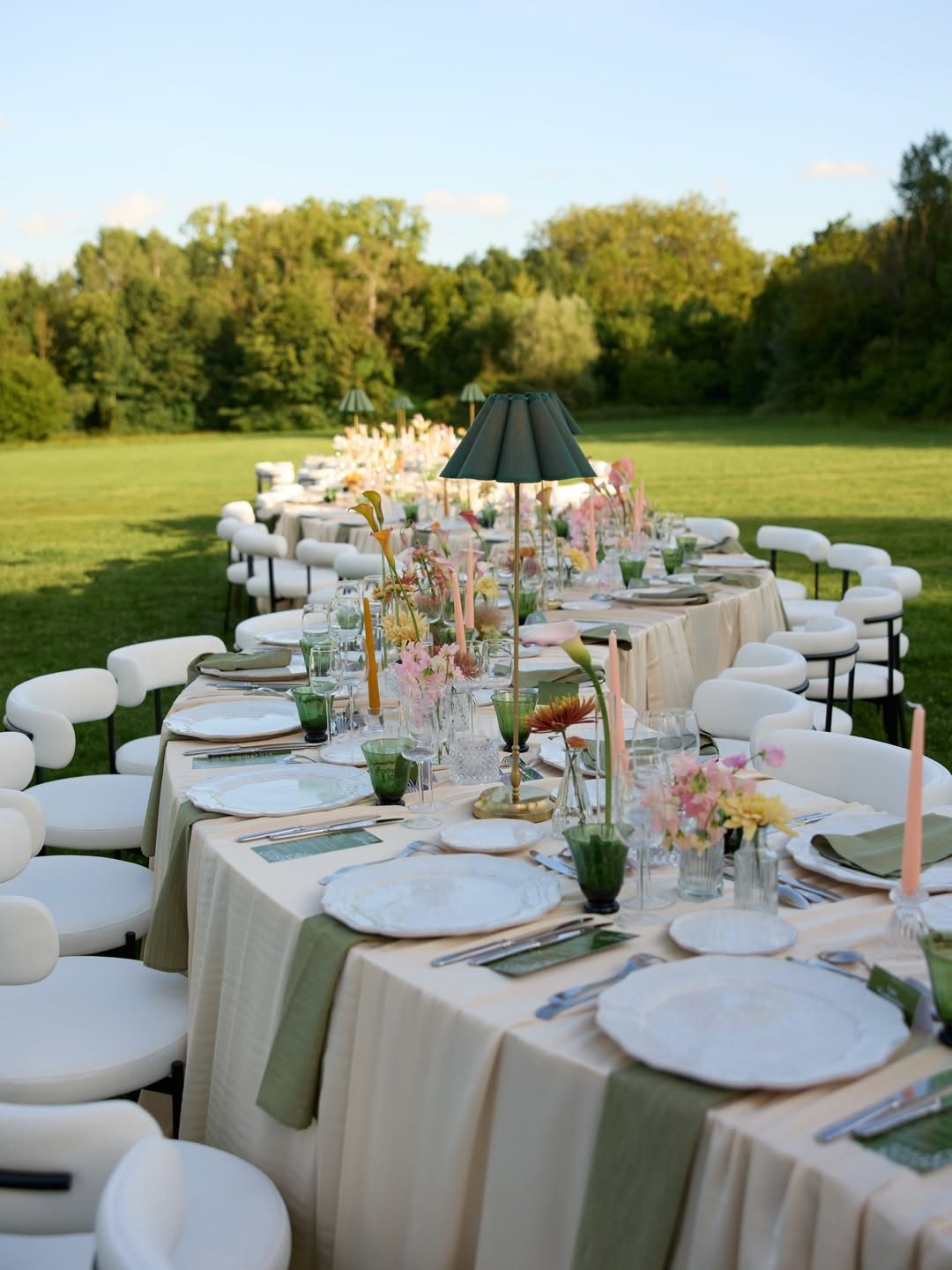 Une longue table dressée dans le parc à la lumière du soir