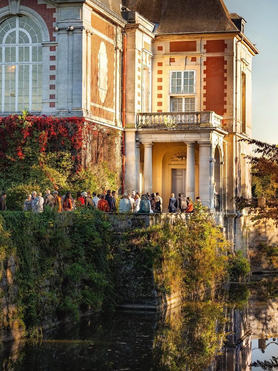 Des invités réunis sous la façade couverte de vigne vierge en automne