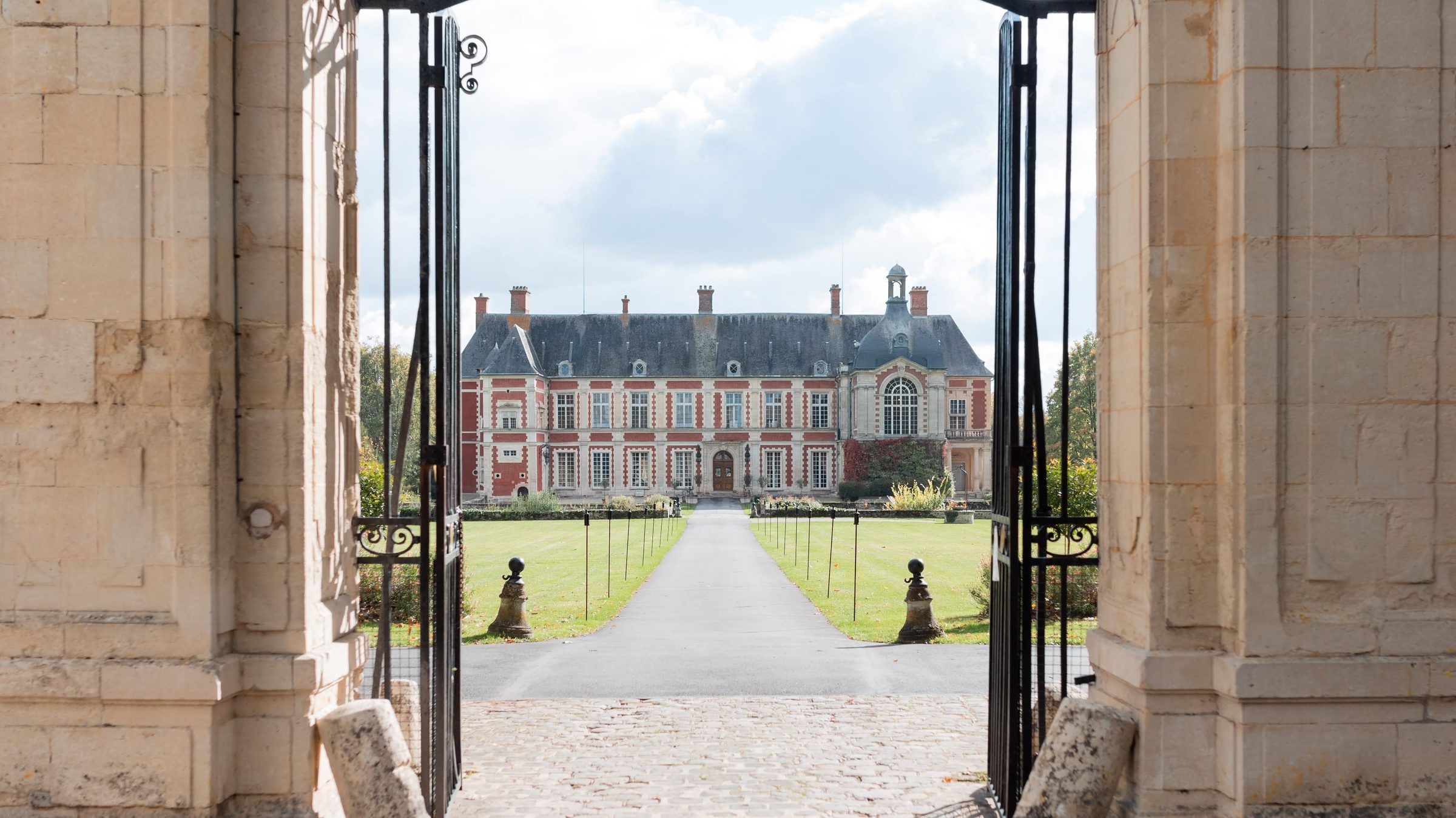 La façade du château vue depuis la grille d'honneur, les portes ouvertes sur l'allée