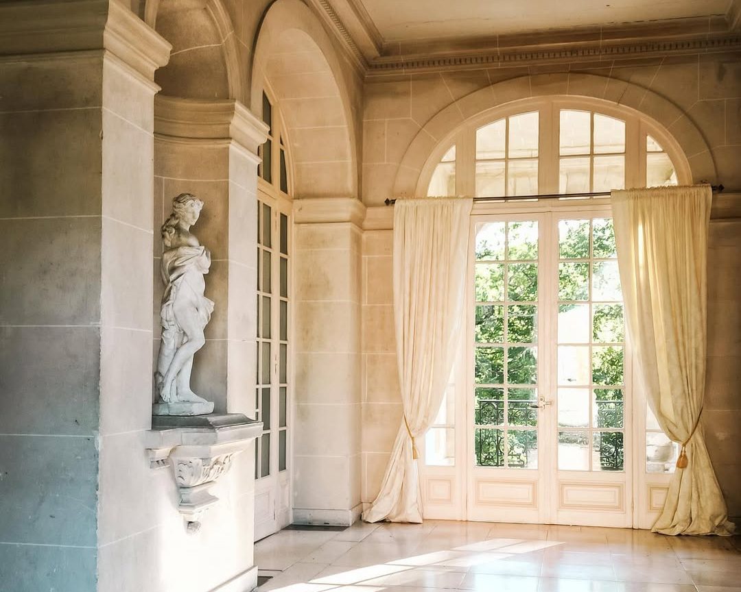 Une galerie claire, statue en niche et porte-fenêtre en plein cintre